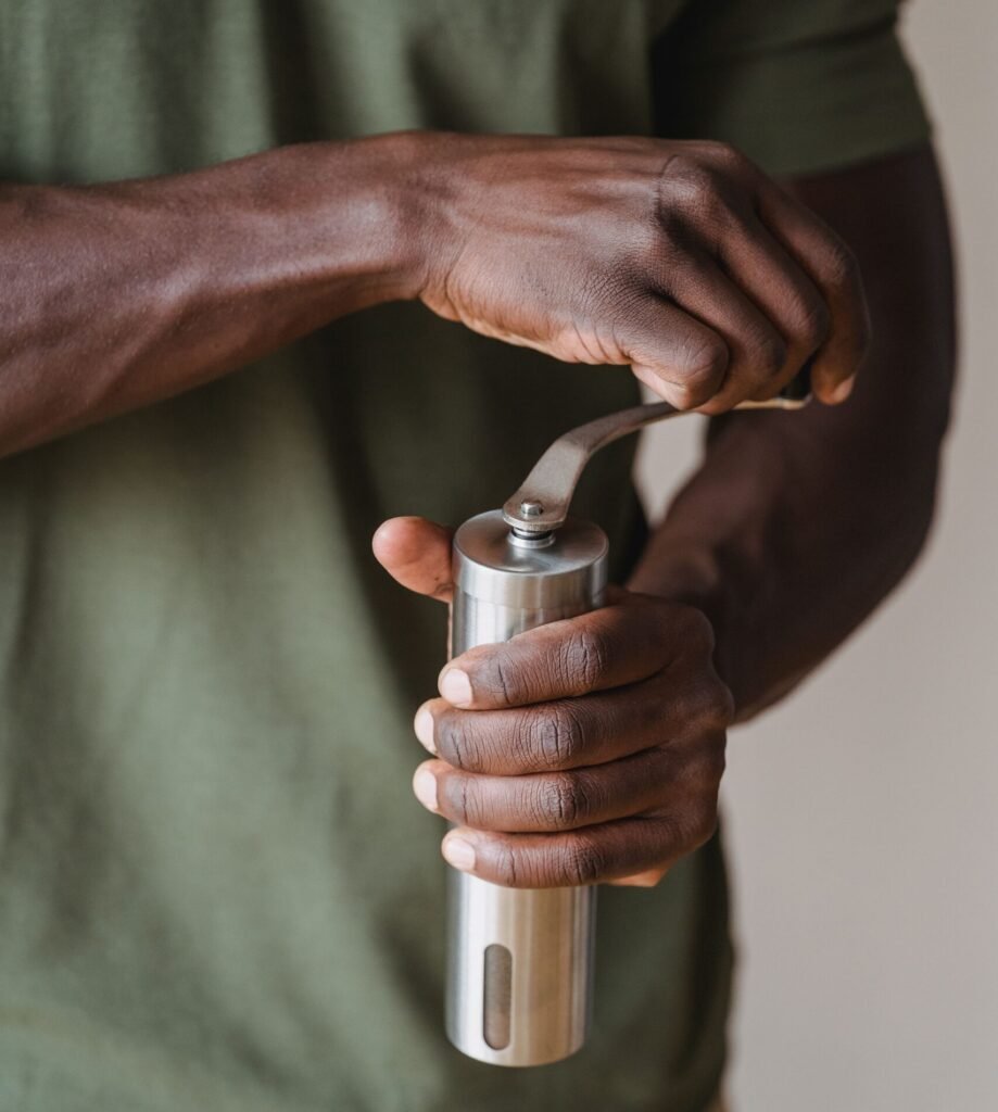 person using a manual pepper grinder in a kitchen