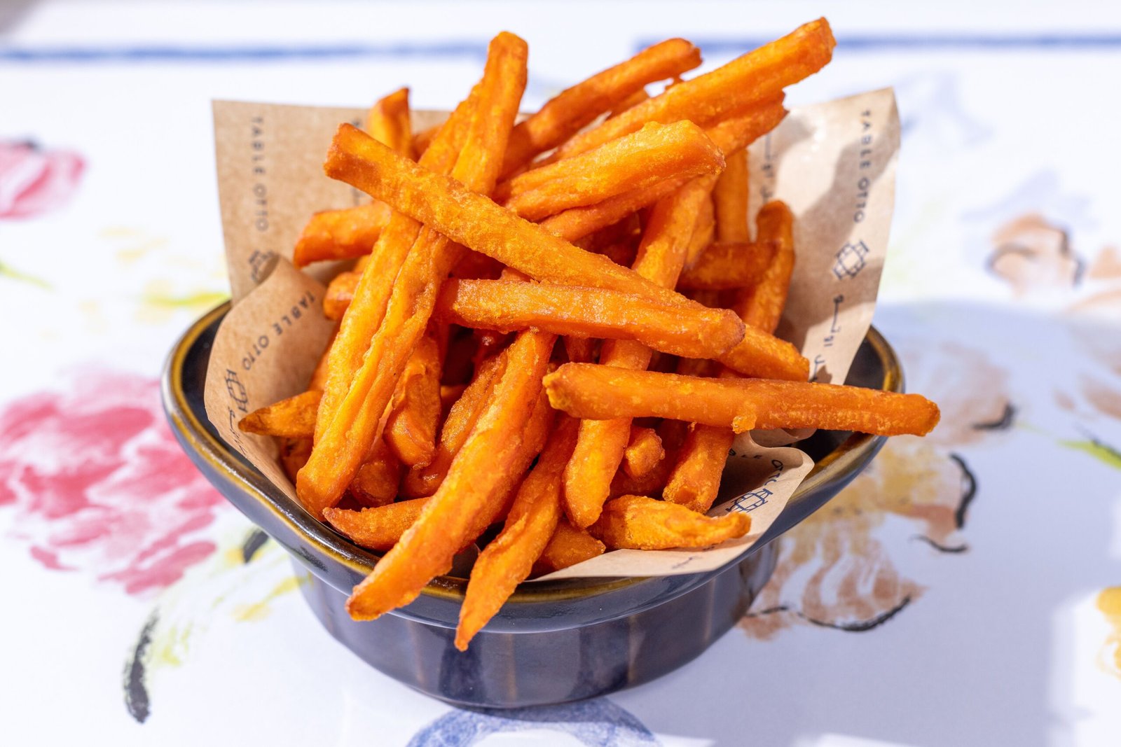 A bowl of crispy sweet potato fries served as a side dish