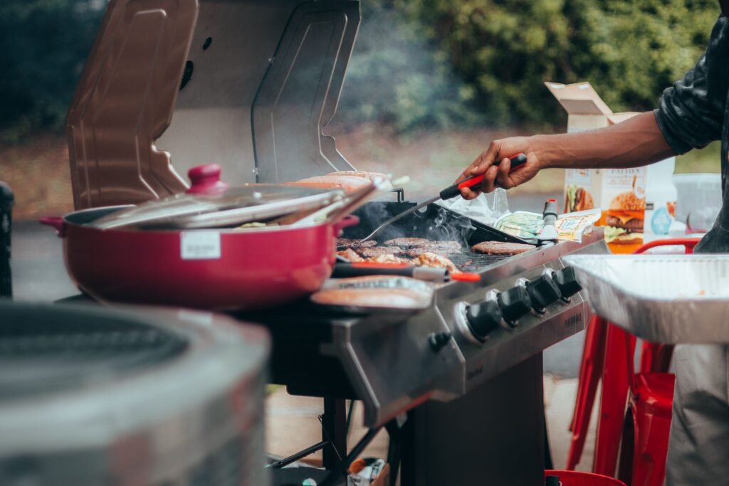 Smoke rising from meat grilling on an outdoor barbecue, similar to using wood pellets on a gas grill