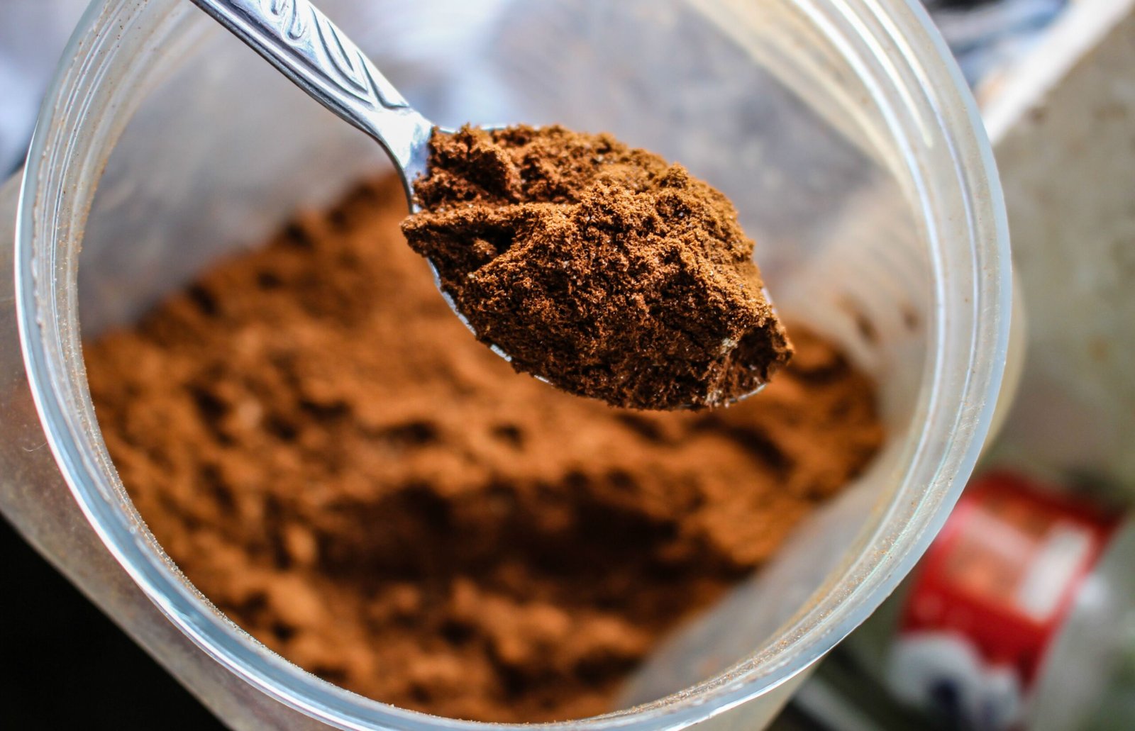 spoon scooping cocoa powder from a container