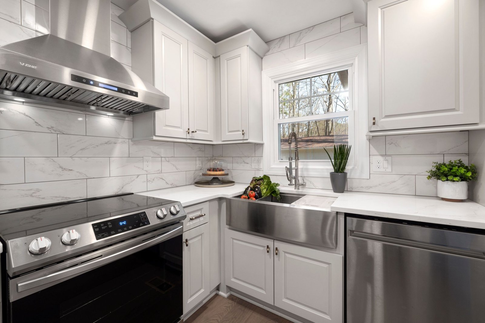 Stainless steel oven and range hood in a white kitchen