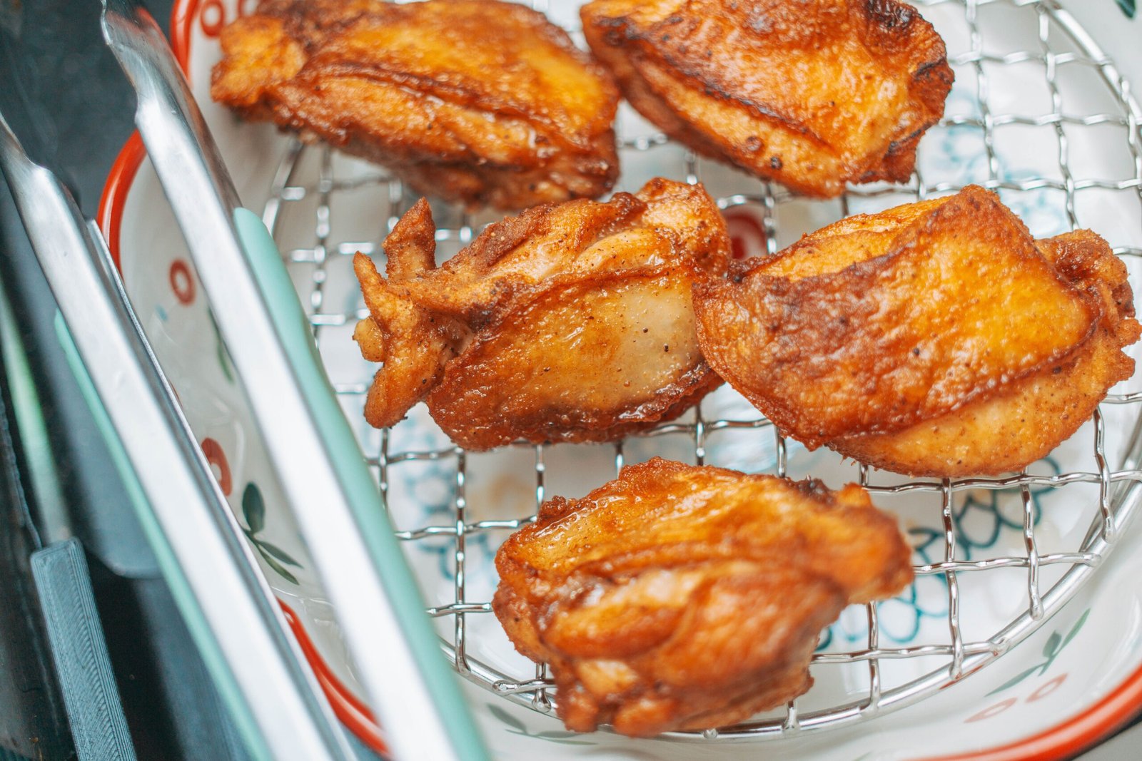 Crispy golden fried chicken pieces cooling on a wire rack