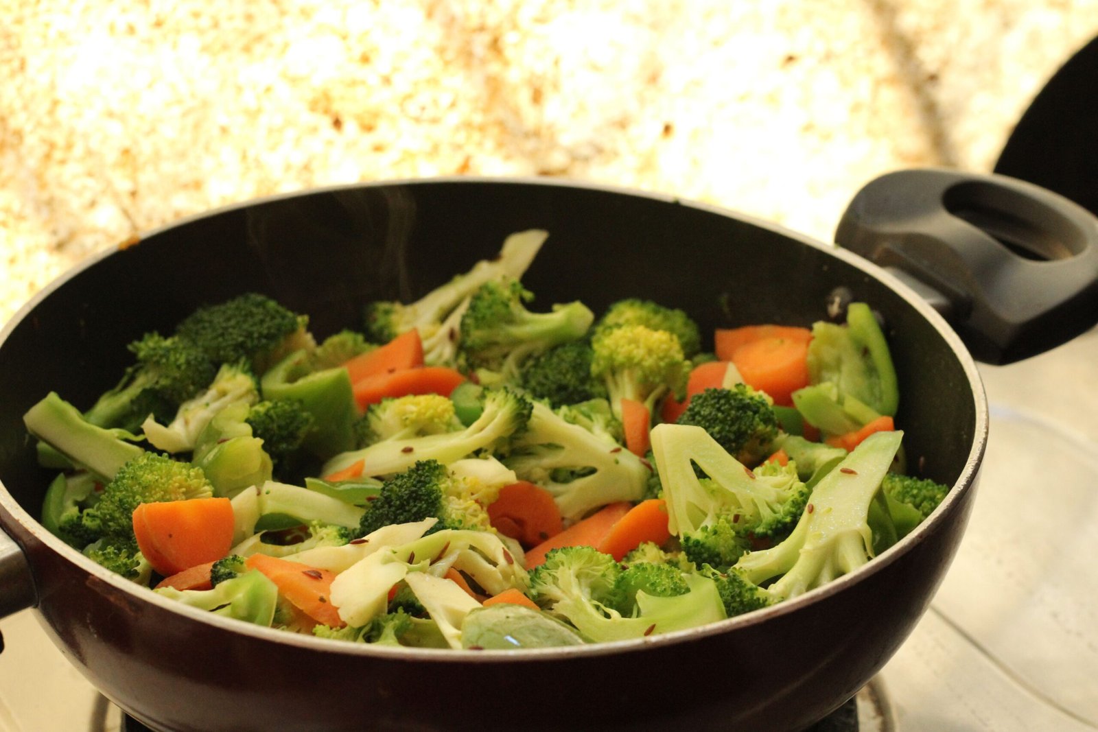 Broccoli and carrots cooking together, ready to be added to a steamer basket