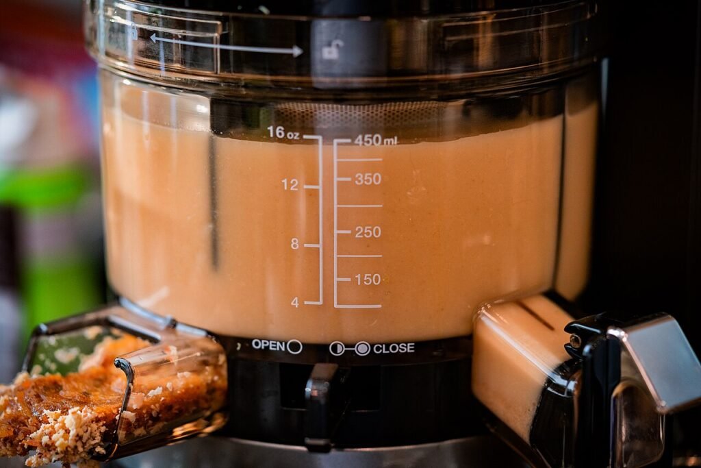 Masticating cold-press juicer extracting juice slowly
