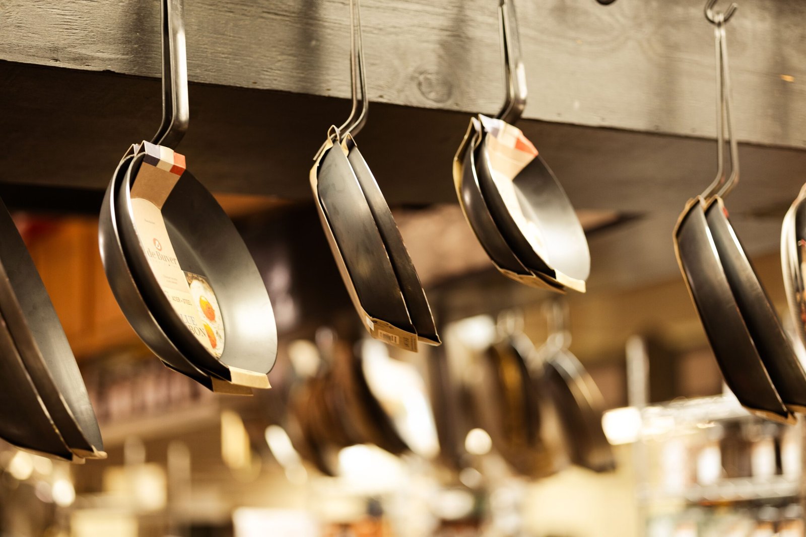 variety of frying pans on display in a kitchenware store