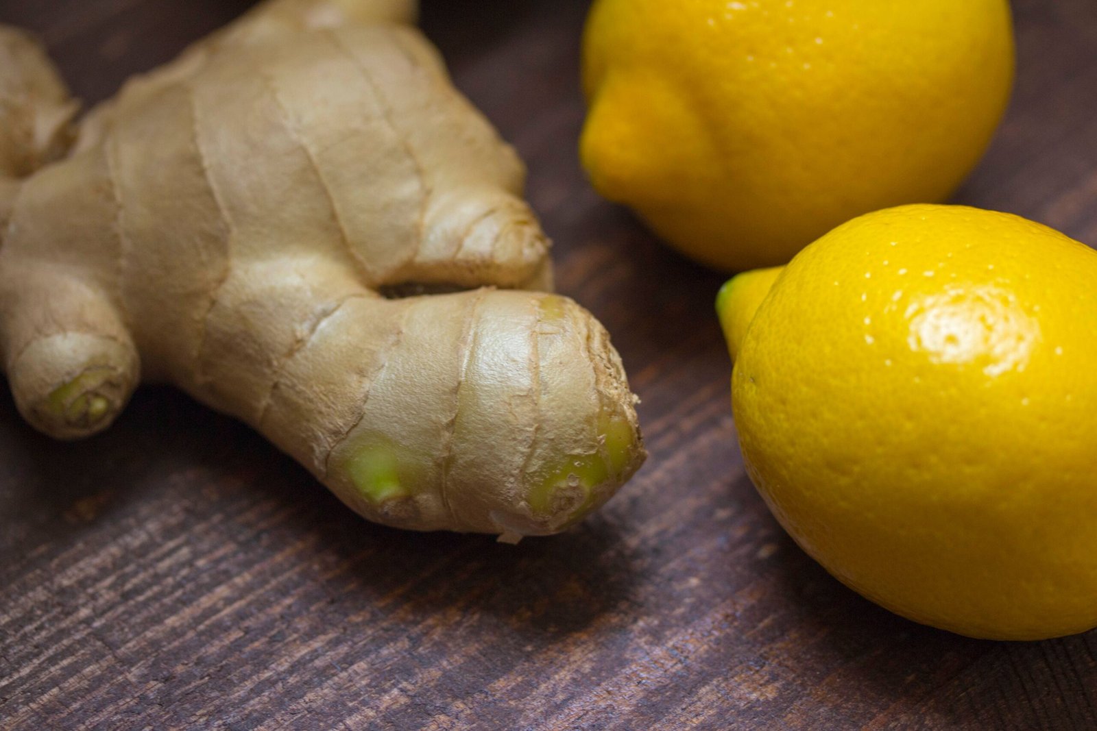 fresh ginger root and lemons on a wooden surface, ingredients for ginger juice