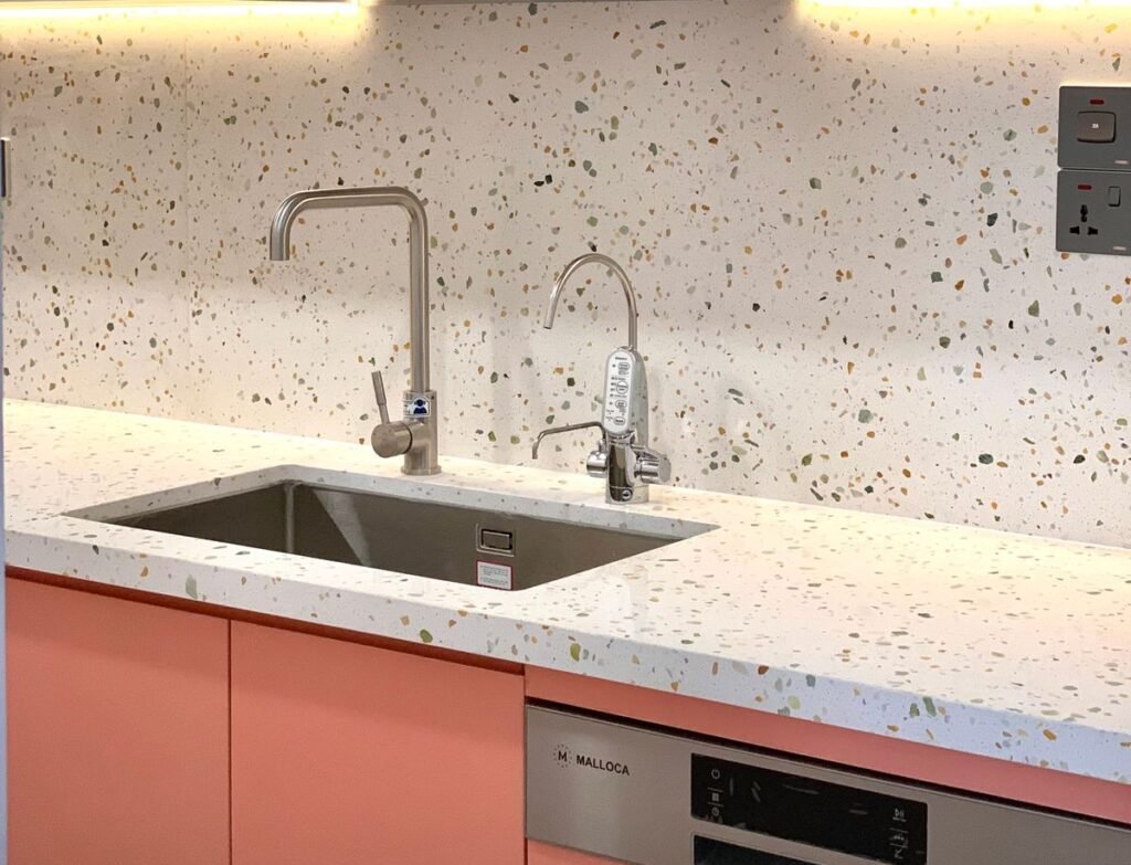 Stainless steel kitchen sink where a dishwasher air gap or high loop connects