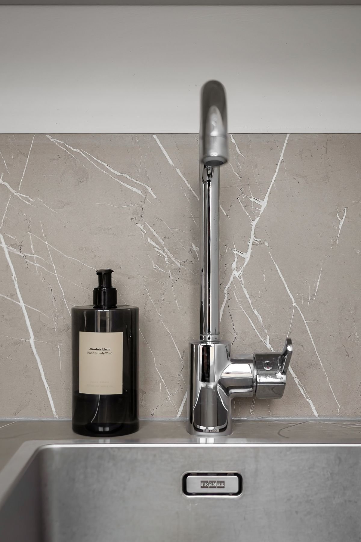 Close-up of a kitchen sink and faucet, the connection point for a portable dishwasher's adapter