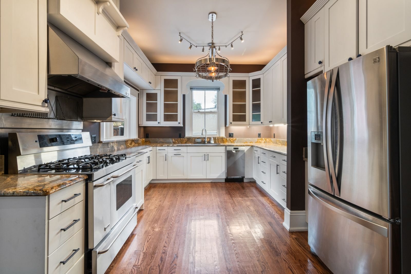 modern kitchen with stainless steel range, refrigerator, and range hood
