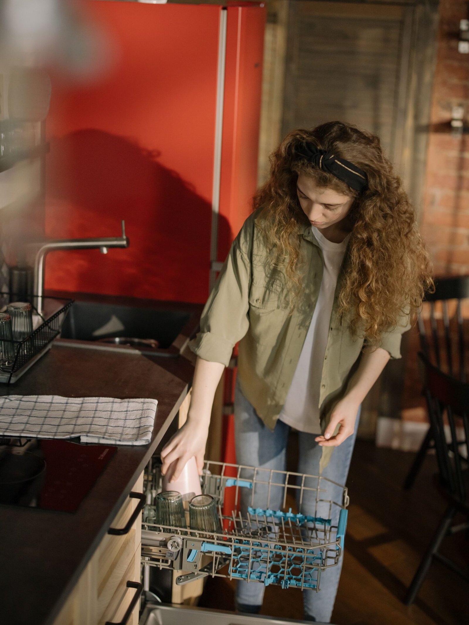 woman loading dishes into a dishwasher with proper spacing between items