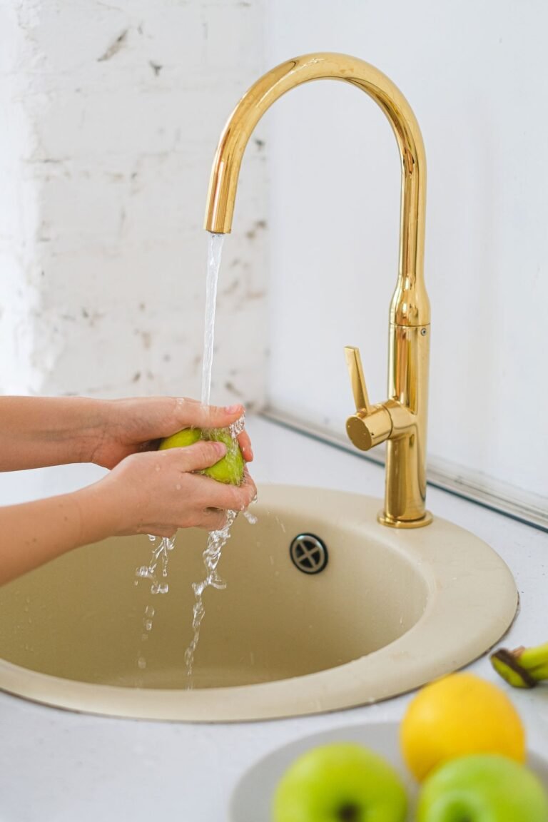 hand positioned under a kitchen faucet, the kind of touch or presence a touch faucet sensor detects