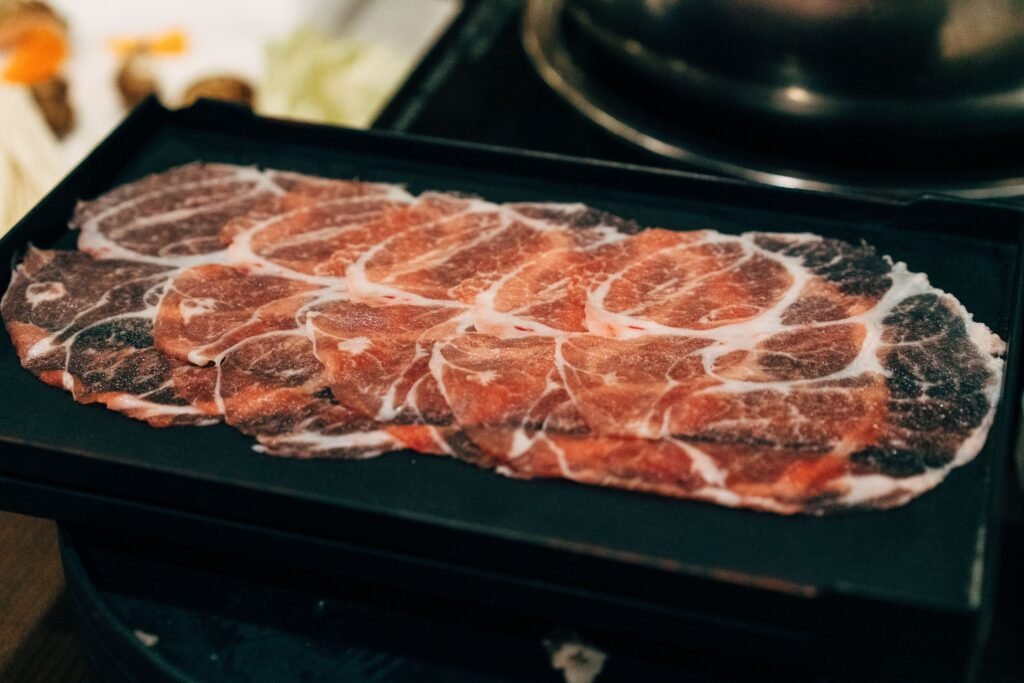 close-up of thinly sliced raw meat on a tray