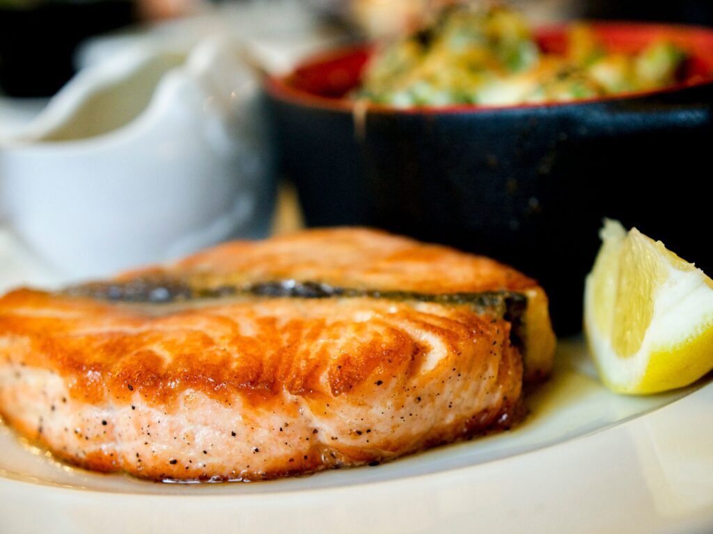 pan-seared salmon fillet plated with a lemon slice