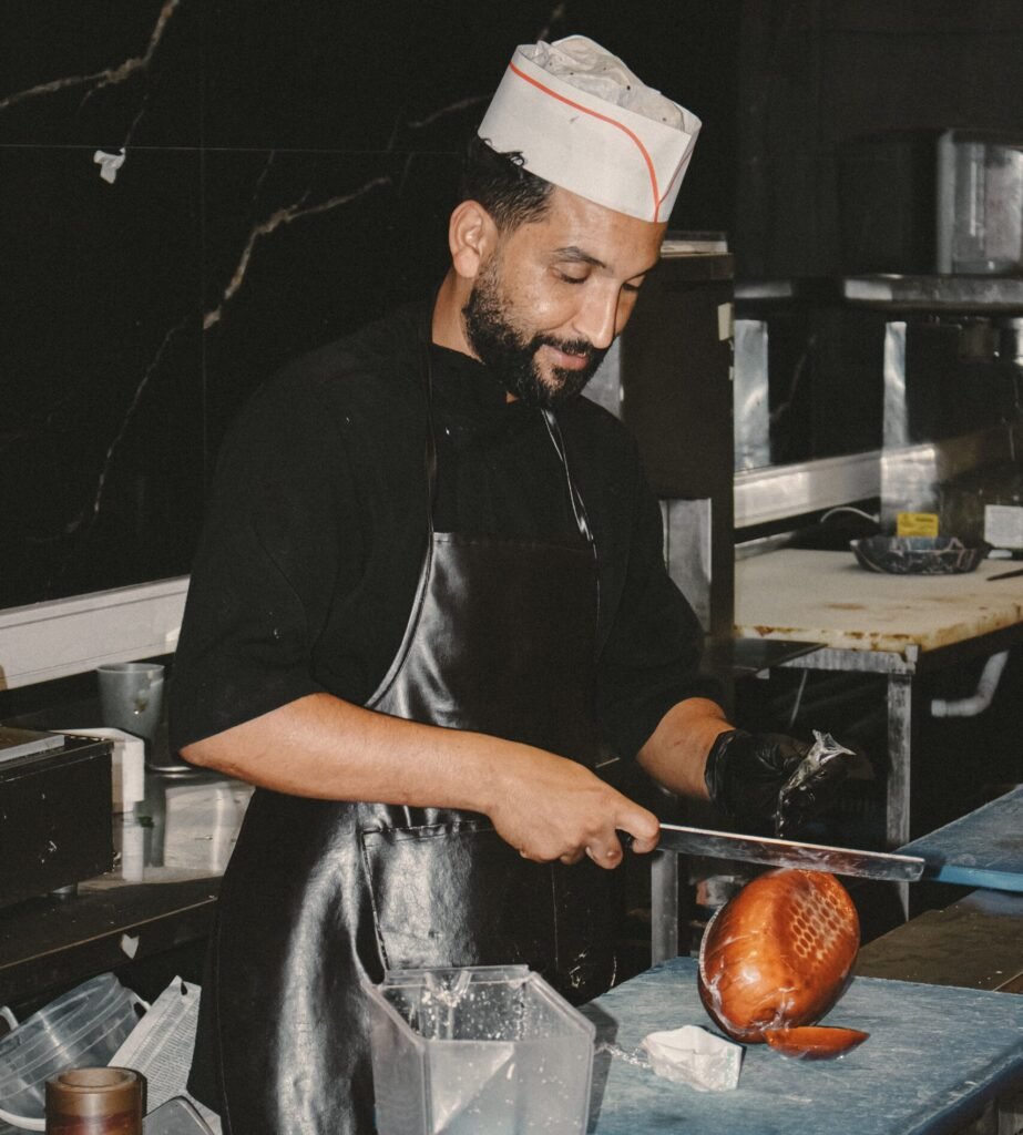 What is a slicer knife used for: clean single-stroke cuts chef slicing smoked ham with a long slicing knife