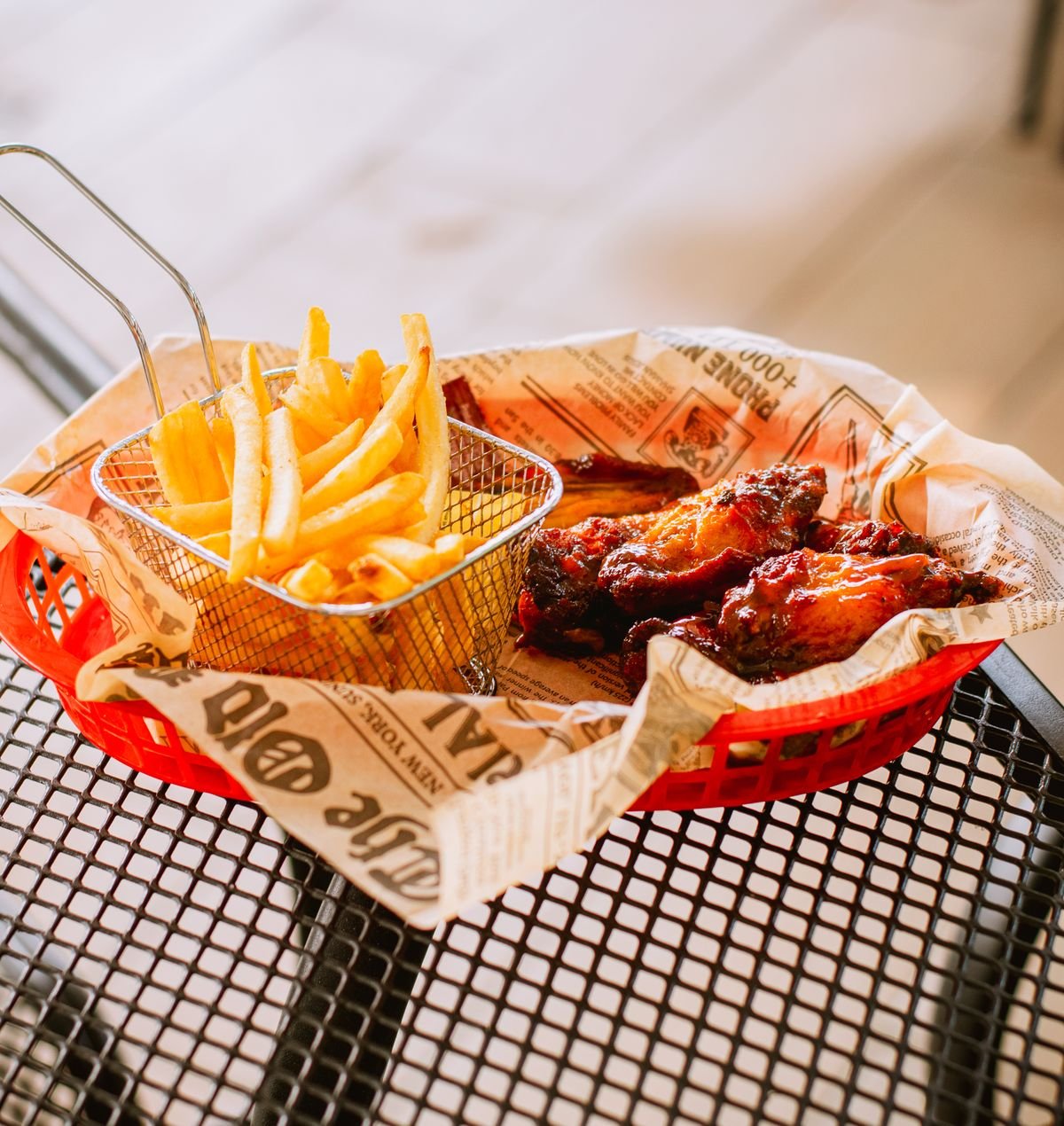 Crispy fries and saucy chicken wings served in a basket