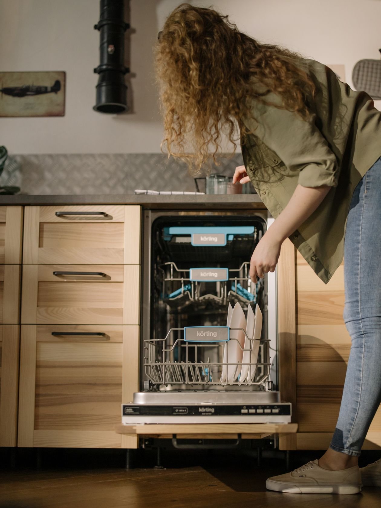 Woman loading dishes into a built-in dishwasher