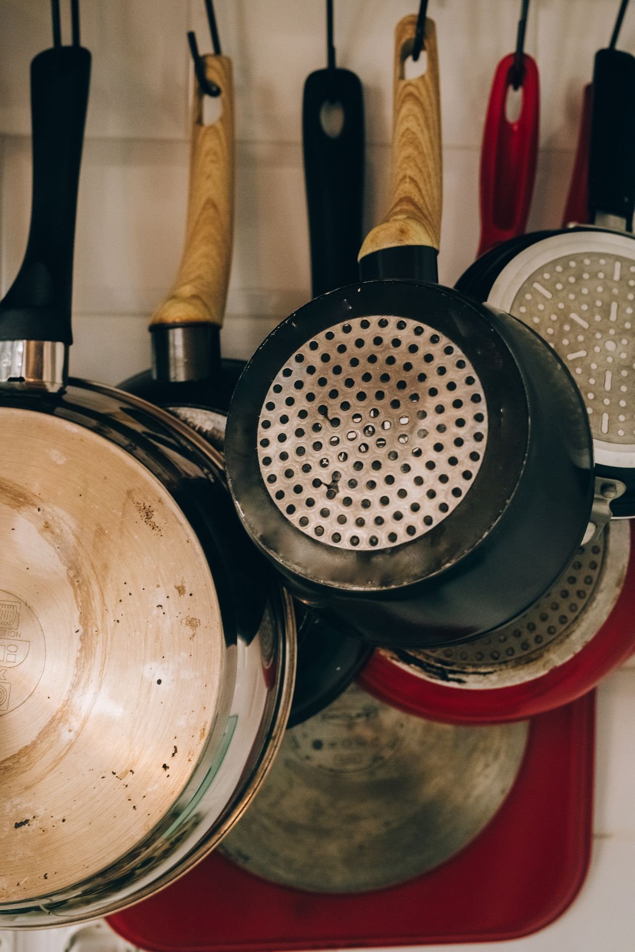 Metal frying pans hanging on hooks in a kitchen