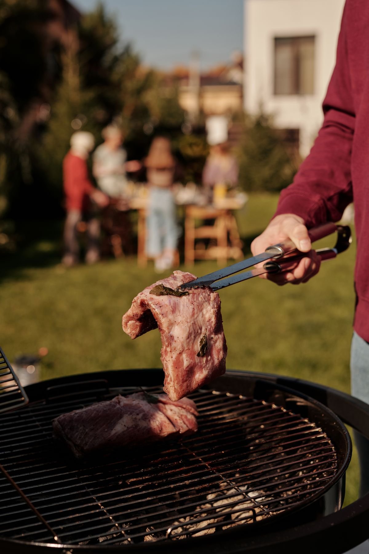 Friends gathered around a backyard barbecue grilling and socializing
