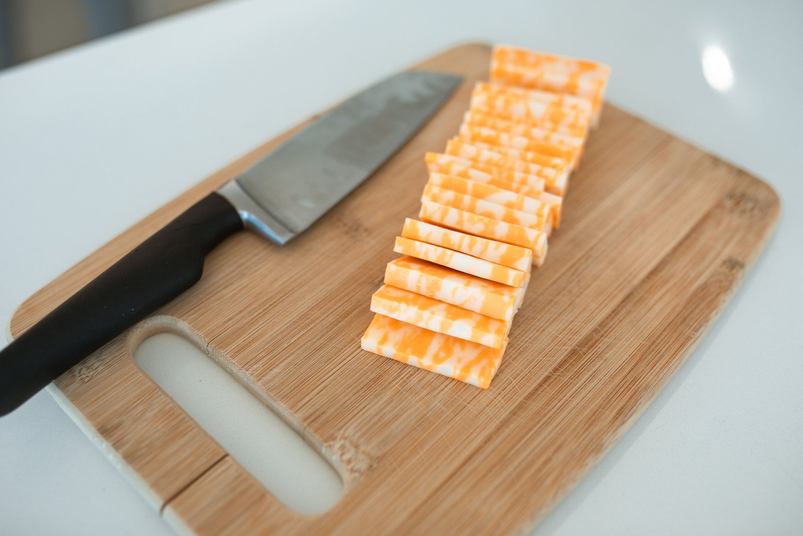 sliced cheese on a wooden cutting board