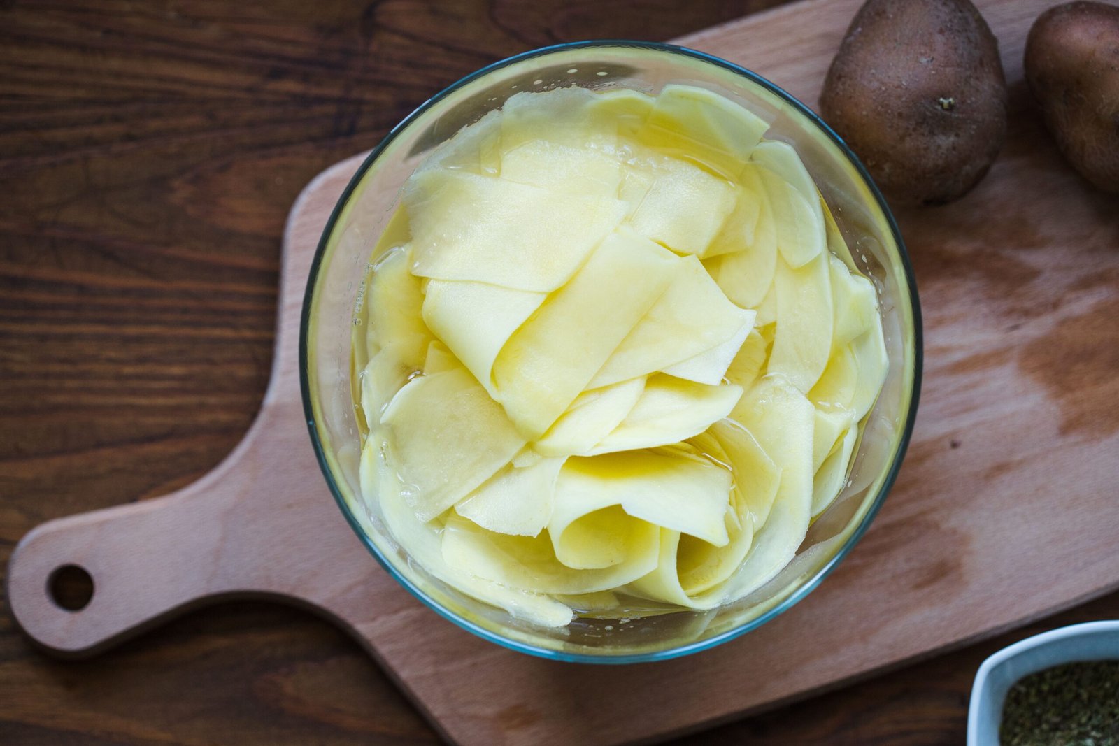 thin potato slices in a bowl ready for wavy cutting