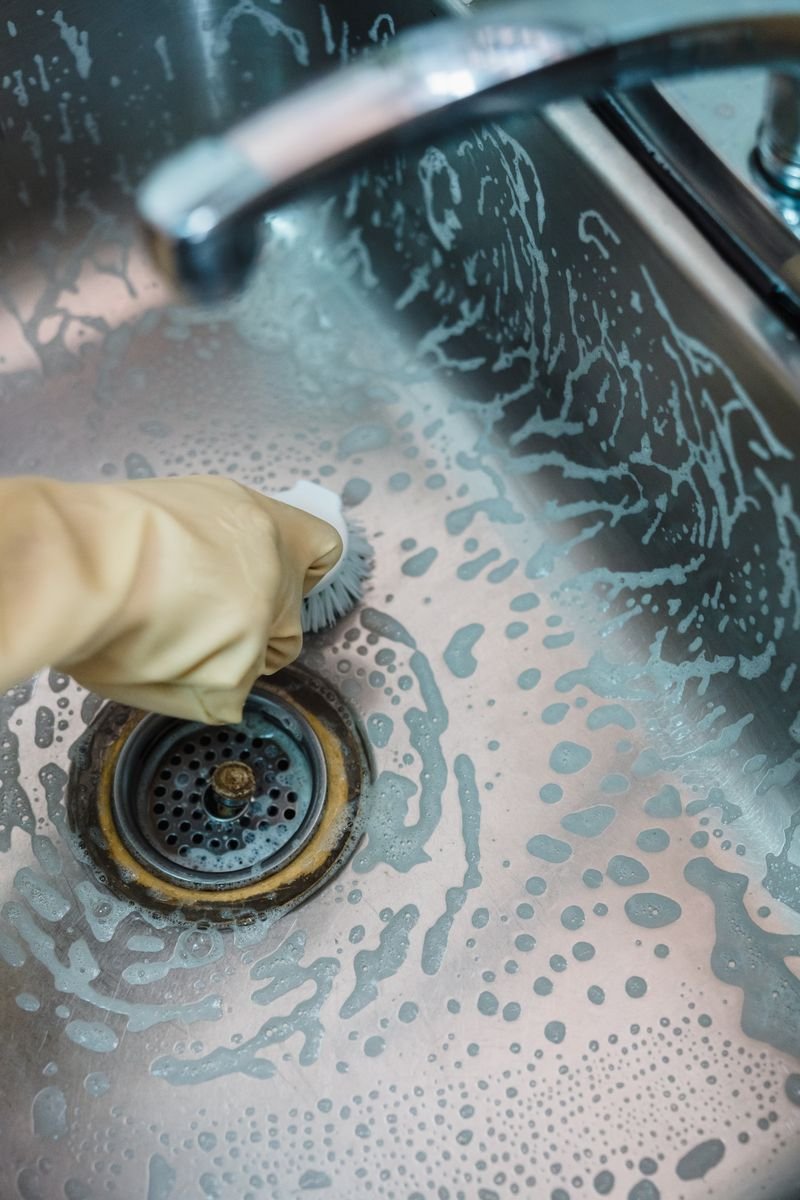 Cleaning a stainless steel kitchen sink to keep the garbage disposal and dishwasher drain fresh