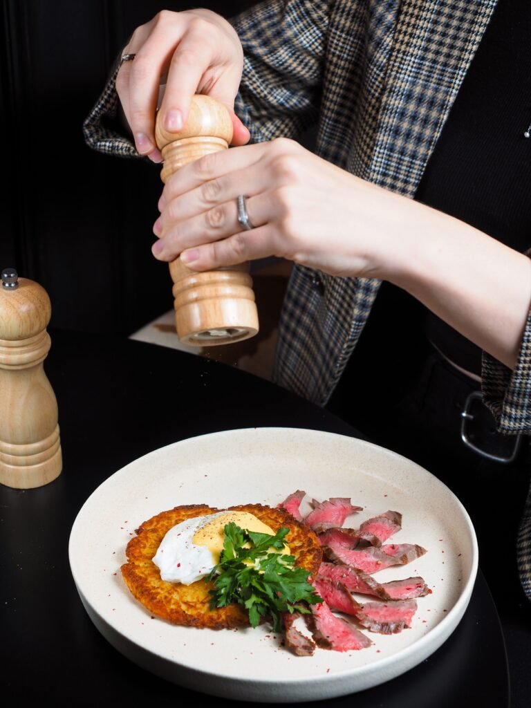 seasoning a plated dish with a pepper mill