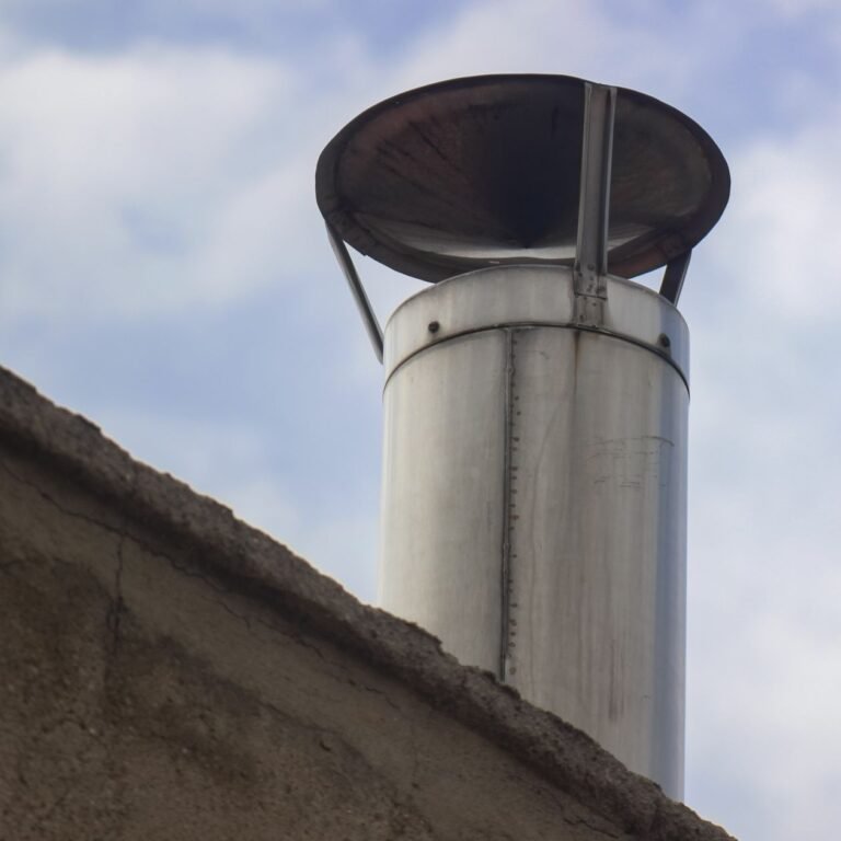 steel chimney vent pipe terminating above a rooftop