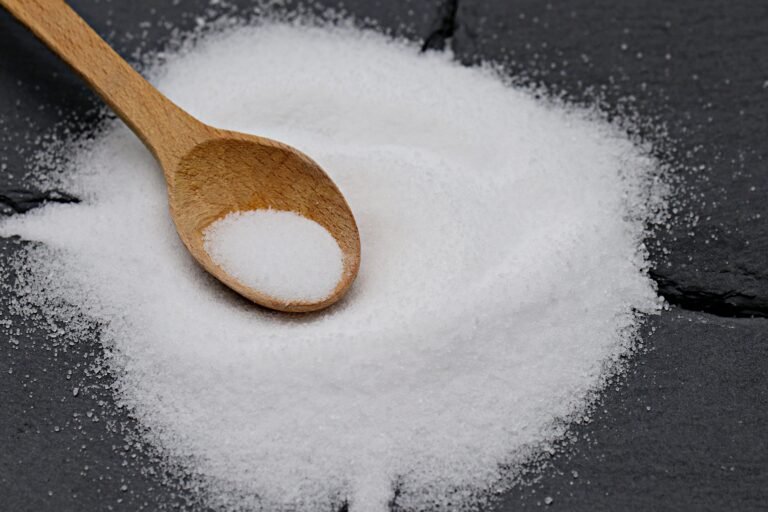 wooden spoon with coarse sea salt on a dark background
